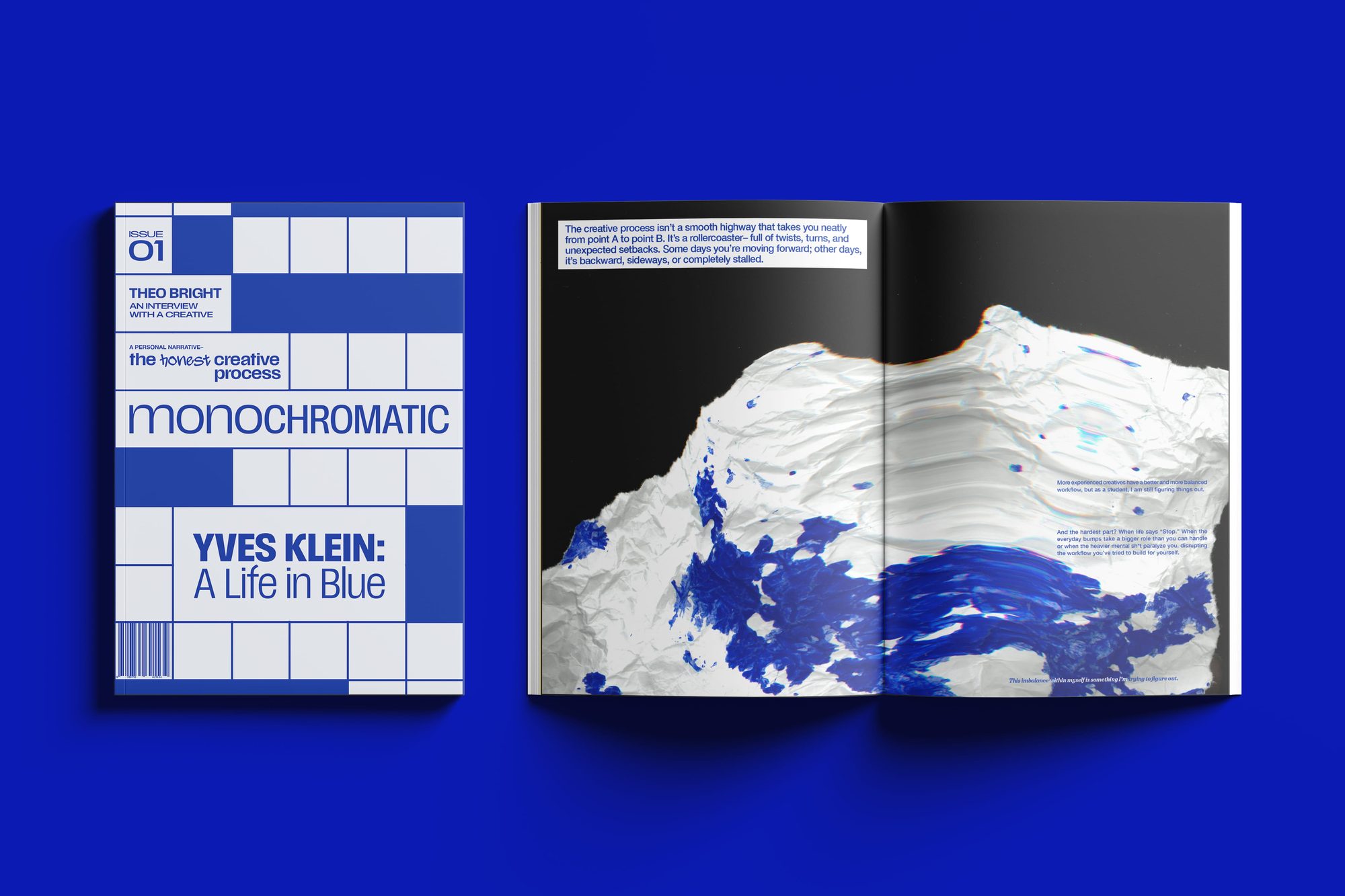 The magazine mocked up on a blue surface: the crossword-grid cover beside the open paint spread