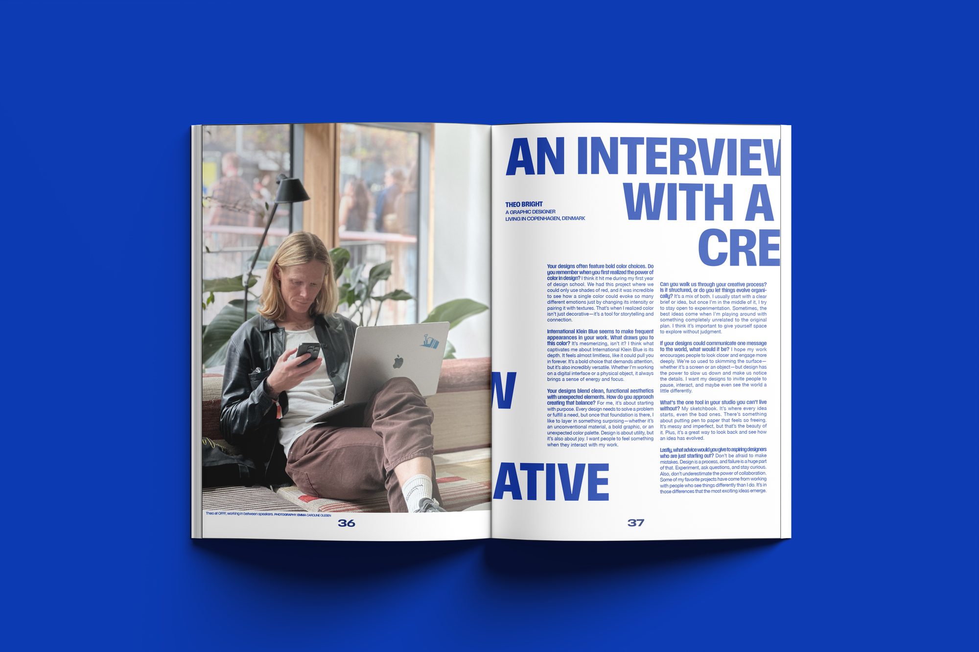 The interview spread mocked up on a blue surface: a photo of the subject on a sofa facing the headline An Interview With A Creative in large blue type